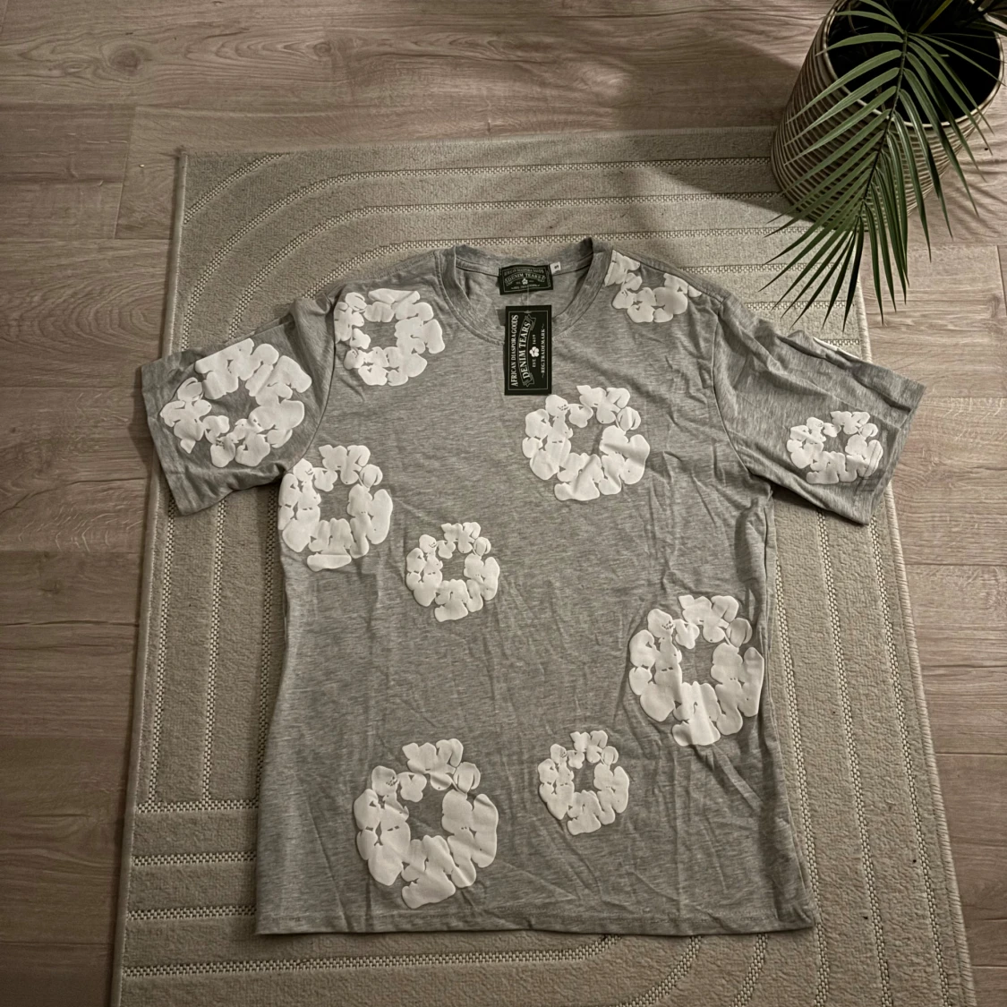 Grå t-shirt med vita blommor från  Denim Tears