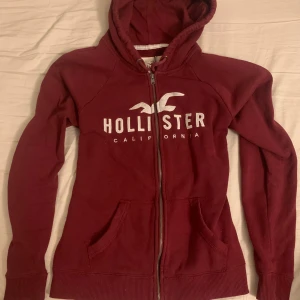 Hollister zip up - Fin vinröd hollister zip up som inte längre kommer till någon användning. Den är lite nopprig och har en mindre defekt (se bild 4 & 5) men är nog lätt att laga. Storlek L och skulle säga att den är true to size. Skriv i DM om ni har några frågor eller vill förhandla kring priset 🙏