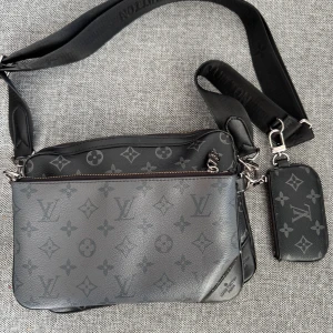 Axelväska  - Axelväska med 2 stora fack samt en liten plånbokshållare, alla facken är avtagbara 