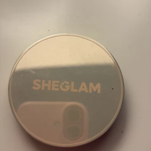 SHEGLAM Silk Haze Cream Bronzer Umber - SHEGLAM Silk Haze Cream Bronzer i färgen Umber. Krämig bronzer i en rund burk med spegelliknande lock. Ger en varm, djup brun ton och är perfekt för att skapa konturer eller ge ansiktet en solkysst look.