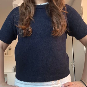 Marinblå stickad t-shirt  - Supersnygg, stilren marinblå stickad T-shirt från Nelly i storleken XS, passar även S. Använd några gånger men inga defekter.