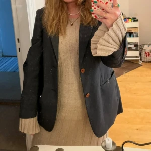 Lång klänning från Wera - Klänning från Wera köpt på Åhléns. Storlek M. 90% bomull 10% polyamid, lappen är dock avklippt. Använd 3 gånger. Finns några få lösa trådar, se bild. ”Grov” i materialet och klänningen är tung. Den är även lång, går ända ner till marken på mig som är 160cm. Åtsittande passform upptill med utsvängda ärmar och går ut nedtill. Inköpt för 1000kr. 