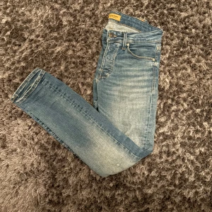 Slim Glenn blå jeans med slitningar från Jack & Jones - Snygga blå jeans från Jack & Jones, modell Slim Glenn. Jeansen har en slim passform, klassisk femficksdesign och ljus tvätt med lätt slitna detaljer. Perfekta för dig som gillar en stilren look. Köpte de för 800 kr på Jack and Jones.