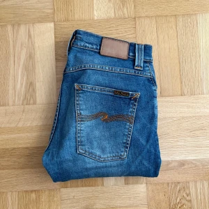 Nudie Jeans - Riktigt feta Nudie Jeans i färgen blå/ljusblå och modellen Grim Tim (=slim/straight) Jeansen är i gott skick och har mycket kvar att ge. Vid frågor eller önskemål om mått är det bara att höra av sig!