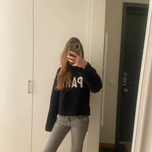 Grå jeans med broderad ficka - Säljer ett par grå jeans med snygg broderad detalj och blomknapp på bakfickan. Byxorna har klassisk femficksdesign och raka ben. Materialet är slitstarkt jeans och färgen är en neutral grå som passar till det mesta. Perfekt för dig som gillar unika detaljer.