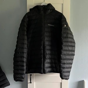 Svart dunjacka Peak Performance XL - Svart dunjacka från Peak Performance i storlek XL men passar även L. Den är använd ett fåtal gånger på grund av för stor storlek, finns inget slitage på den. Köpte den förra vintern ny för 2800kr