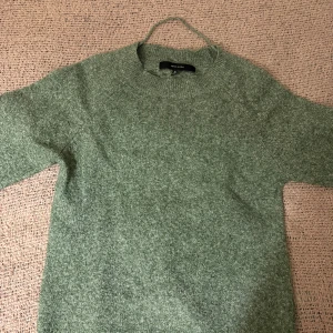 Grön stickad tröja från Vero Moda XS - Mysig grön stickad tröja från Vero Moda i storlek XS. Tröjan har rund halsringning, ribbade muddar och är perfekt för kyligare dagar. Enkel och stilren design som passar till många olika outfits.