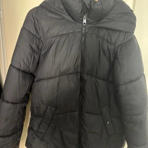 Svart pufferjacka från Vero Moda - Svart pufferjacka från Vero Moda med huva och dragkedja framtill. Bra skick, inga synliga defekter 