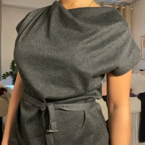 Topp med snygg krage  - Från HM, endast använd 1 gång. Man kan antingen knyta den i midjan (som på bilden) eller använda bandet som ett ”skärp. Supersnygg men kommer inte använda den mer.