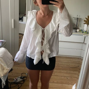 Söt blus från Boohoo - Blus i nyskick med knytning fram, vringning och volanger. Helt i nyskick och snygga detaljer vid ärmslutet💗