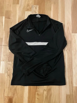 Nike Dri Fit Tracksuit - Säljer nu ett riktigt fräscht träningsset från Nike i klassiskt svart och vitt. Materialet är Nike Dri-FIT som andas och håller dig torr, vilket gör det perfekt för både träning och vardag. Hela setet är i princip i perfekt skick helt utan defekter. Storleken är 158–170 (Junior XL), vilket motsvarar en XS eller en mindre S i vuxenstorlek. Passformen är sportig och bekväm. Jag säljer delarna separat för 160 kr för byxorna och 180 kr för tröjan. Om du köper hela setet får du det för endast 300 kr.