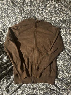 Brun kofta från Massimo Dutti - Säljer en brun kofta från Massimo Dutti med dragkedja framtill. Tröjan är tillverkad i en mjuk blandning av bomull och kashmir, har ribbade muddar och långärmad design. Perfekt för dig som gillar stilrena och bekväma plagg. Skriv gärna prisförslag 