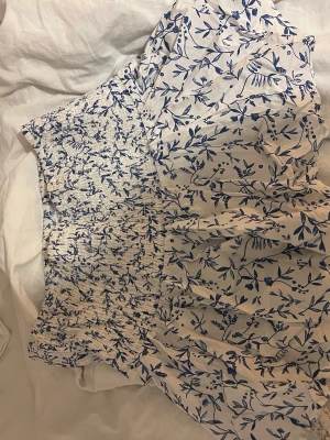 Vit kortklänning med blått blommönster - Supersöt kjol i vitt med blått blommönster. 