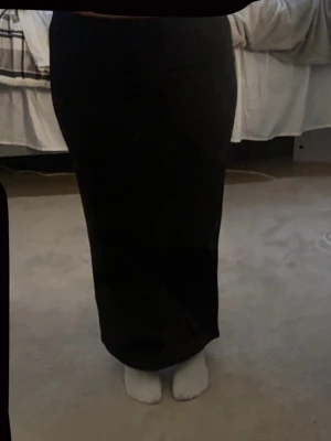 Svart långkjol från lager 157, XS - Säljer en svart långkjol från lager 157 i storlek XS. Kjolen har en rak och figurnära passform med en snygg slits bak för extra rörelsefrihet. Enkel och stilren design som är lätt att matcha med olika toppar och accessoarer. Använd 1 gång.