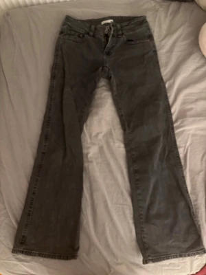 Svarta jeans från Gina Tricot🫶🏻 - Säljer ett par svarta lite åt det vagga hållet, men ändå lite bootcut lågmidjadr jeans från Gina Tricot, från Perfect Jeans. De har klassiska fickor med lock och knapp bak, samt snygga sömdetaljer. Jeansen har normal passform och är tillverkade i ett mjukt jeansmaterial. Jättesnygga tillsammans med en sommartopp eller hoodie!🤍
