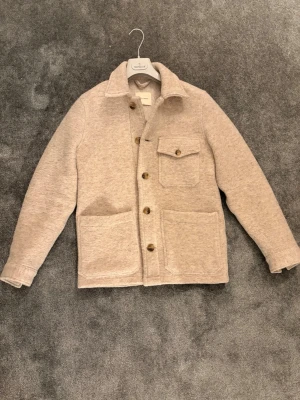Beige overshirt från A Day's March - Säljer en beige overshirt från A Day's March i ullmix. Modellen på bilden är 175cm