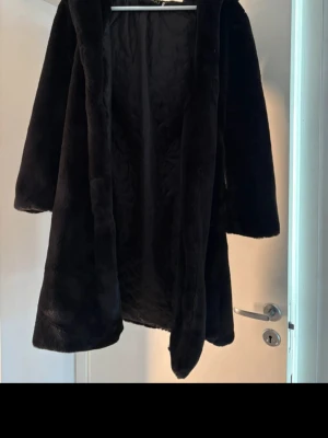 Svart pälsjacka m luva  - Superfin svart pälsjacka säljes! Köpt på Vinted men tyvärr för kort i armarna på mig och allmänt för liten. :(  Jackan är i bra använt skick. Lite nopprig insida men fantastisk fin utsida (pälsen är jättefin).  Storlek XL enligt lapp men skulle säga att den är mer som än XS - liten i storlek! Går till knäna på mig som är 168cm  Obs saknas någon ögla för att stänga jackan högst upp. Lätt att sy fast, jag köpte den såhär.     #pälsjacka #fauxfur #black #blackfur #furcoat #coat #luva #hood #bla