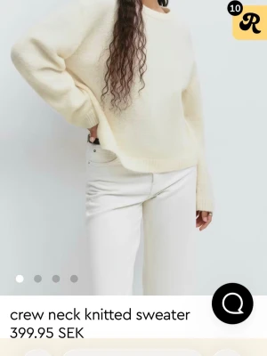 stickad tröja - Mysig vit stickad tröja med rund hals och avslappnad passform. Tröjan har långa ärmar och ribbade muddar vid ärmslut och nederkant. Perfekt för lager på lager under kyligare dagar.