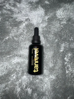 Tanrevel Spray Tan Formula Dark Cool - Tanrevel Spray Tan Formula i färgen Dark Cool, 40 ml. Kommer i en svart glasflaska med pipett och guldig text. Perfekt för att få en fräsch solkysst look snabbt och enkelt hemma. Passar till Tanrevels spraytan-maskin.