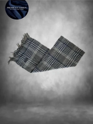  grå halsduk från Burberrys - .Tja! Säljer en klassisk halsduk från Burberrys i grått, blått och vitt rutmönster. Halsduken är tillverkad i 100% lammull och har tvinnade fransar i ändarna. Perfekt accessoar för att soppa upp vinterlooken med en tidlös skön outfit! Denna färg är rätt sällsynt men fortfarande väldigt snygg enligt mig🤩skicket är 10/10 alltså som ny kortfattat! Den passar bra till allt och är bara allmänt snygg🤗denna modell är vintage och slutade tillverkas senast 1999! Hör av dig vid fråga! Mvh premium fashion🤗