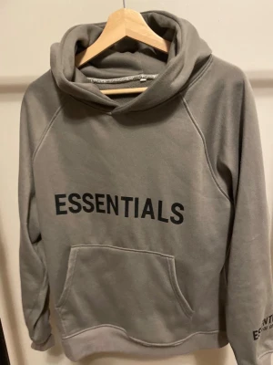 Grå Hoodie från Essentials - Mycket bra skick.