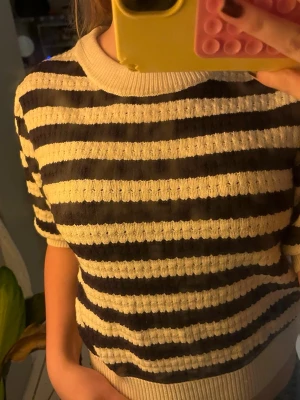 Randig stickad tröja från Zara - Säljer en kortärmad stickad tröja från Zara med breda marinblå och vita ränder💙💙. Tröjan har ribbad rund hals och nederkant, samt en lite croppad passform. Perfekt för dig som gillar klassisk stil med en twist.🍵🍵