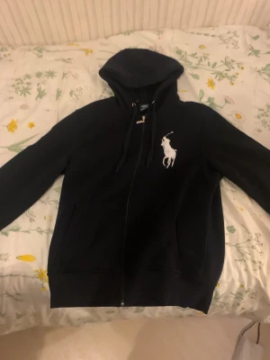 Svart Polo: Ralph Lauren hoodie ( small men passar mig som är 182) - 🚨Pris kan diskuteras 🚨Svart Polo: Ralph Lauren hoodie med dragkedja och magficka. Stort Polo: Ralph Lauren märke på högra sidan i brösthöjd. Ser blå ut på bilder tagna med blixt men den är svart i verkligheten eller väldigt väldigt mörkblå. Använd några få gånger