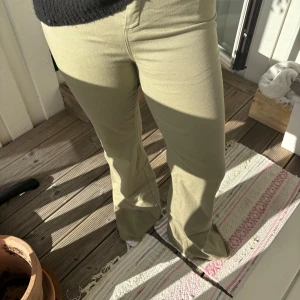 Trendiga kakhi jeans! - Snygga low/mid waist kakhi gröna jeans från design By si med bootcut-modell och fransig upp till midjan. Byxorna har normal passform och skulle säga att det är mid waist. De har ett litet hål på bakfickan som man kan se på sista bilden, men det är inget man ser tydligt i verkligheten💚