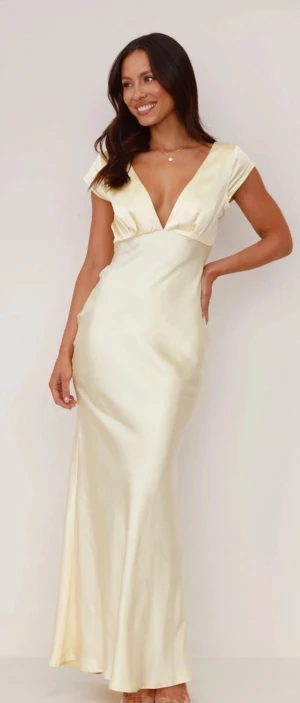 Champagnefärgad långklänning med v-ringning - Säljer en elegant långklänning i champagnefärgad satin med djup v-ringning fram och öppen rygg med snygg cut-out. 