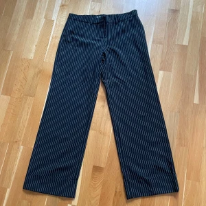 Oversized kostymbyxor - Kritrandiga oversized kostymbyxor i storlek L. Knappt använda low waisted från motel rocks. Dom har en vikning längst ner på benet som syns på bild. Passar mig i längden som är 180cm