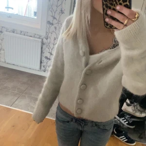 Beige fluffig kofta med stora knappar - Supermjuk och fluffig beige kofta med stora matchande knappar framtill. Storlek S och märke h&m edition 