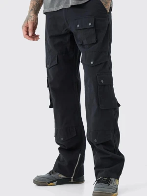 Svarta cargopants med fickor - Svarta cargopants med flera stora fickor med lock och tryckknappar på benen. Byxorna har en loose passform och dragkedjor vid bensluten för extra stil. Perfekta för dig som gillar streetwear och funktionella detaljer.