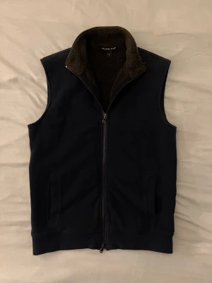 Micheal Kors väst  - Fodrad micheal kors pälsväst, riktigt snygg att ha som underlag under en jacka, varm och skön nu till vintern. 