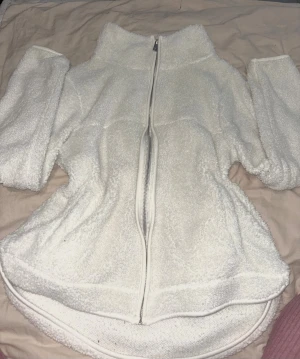 Vit teddyjacka med dragkedja - Mysig vit teddyjacka från 157 med hel dragkedja framtill och hög krage. Jackan är fluffig och har lång ärm, perfekt för kyliga dagar. Enkel och stilren design som passar till många outfits.Säljer då låg för man sen den är inte ny.