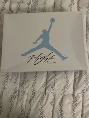 Nike Air Jordan 4 University Blue - Säljer ett par Nike Air Jordan 4 University Blue sneakers i ljusblå mocka med grå och svarta detaljer. Skorna har klassisk meshpanel, snörning och specklad grå hälkappa med Jumpman-logga. Riktigt snygga och eftertraktade sneakers för dig som vill sticka ut. Passar mindre än 44.