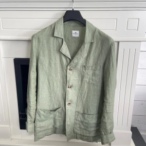 Ljusgrön linnékavaj från John Henric! - Snygg ljusgrön kavaj från John Henric i 100% linne. Kavajen har tre framfickor, klassisk krage och knäppning med tre knappar. Perfekt för dig som gillar en chill och stilren look med naturligt material och avslappnad passform. Knappt använd i skick 9/10, nypris 1300. Tveka inte vid frågor! Mvh Tobias