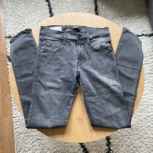 Mörkgråa Replay - Snygga grå jeans från Replay med klassisk femficksdesign och diskreta sömdetaljer på bakfickorna👖 Jeansen har rak passform och normal midja. Perfekta till sneakers eller boots och funkar året runt🙌 Materialet är mjukt och stretchigt jeans🪢  Jeansen är i Anbass modell oh har storlek W29 L34📐  Vid frågor: Meddela oss📩