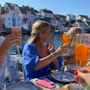 Blå klänning med v-ringning - Snygg blå kortklänning med djup v-ringning. Klänningen har trekvartsärmar med lätt puff och knyt i ryggen. Tillverkad i ett tunt, luftigt material som ger en chill vibe. Perfekt för varma dagar och sommarhäng vid vattnet.