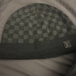 Grå Lv mössa byte/svart?  - Snygg grå mössa från Louis Vuitton med klassiskt Damier-rutmönster. Vill gärna byta den mot en svart som är äkta 