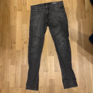 Replay Anbass grå slim jeans W30 L34 - Säljer ett par gråa Replay Anbass jeans i slim fit. Jeansen har klassisk femficksdesign, dragkedjegylf och snyggt tvättad finish, perfekt för dig som gillar en modern look.