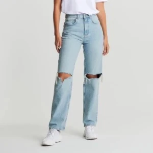 Jeans Gina Tricot - Säljer ett par ljusblå jeans från Gina Tricot med hål på knäna. Knappt använda , storlek 34❣️