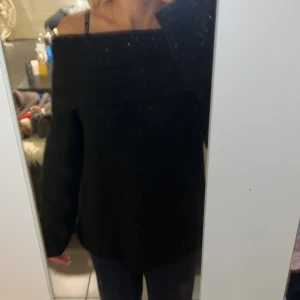 Svart offshoulder stickad tröja H&M XS - Svart stickad tröja från H&M i storlek XS. Tröjan har en bred offshoulder-krage och långa ärmar. Mjuk och skön känsla, perfekt för kyligare dagar. Enkel att styla med både jeans och kjol för en trendig look.