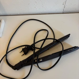 Svart plattång Slim 28 mm - Svart plattång med smal design, 28 mm breda plattor och texten 'wet&dry' på sidan. Har lång sladd med EU-kontakt och passar för både vått och torrt hår. Perfekt för att styla och få till snygga, raka längder eller lockar.