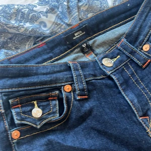 True Religion Becca Bootcut Jeans - Mörkblå jeans från True Religion, modell Becca bootcut men skulle säga att dom sitter low rise ändå då pris går att diskutera💕 dom är storlek 25 passar xs och s! Använda få gånger då dom är för små