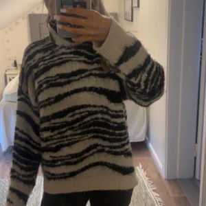 Beige och svart stickad polotröja - Säljer denna superfina zebra tröjan med krage som är helt slutsåld. Köpte för ca 3 veckor sen. Säljer då jag köpte en liknande som jag gillar mer, inga defekter🦓🩷 Storlek S