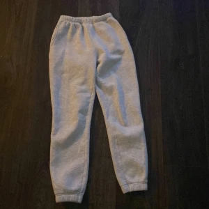 Grå mjukisbyxor från Gina Tricot XXS - Grå mjukisbyxor från Gina Tricot, basically basics-kollektionen. Byxorna har resår i midjan och vid bensluten samt sidofickor. Perfekta för chill dagar och enkel stil. Mjukt material som känns skönt mot huden.