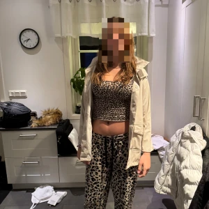 Beige regnjacka med huva - Snygg beige regnjacka med huva och stora fickor framtill. Jackan har en rak passform och stängs med knappar. Perfekt för blöta dagar och enkel att matcha med olika outfits.