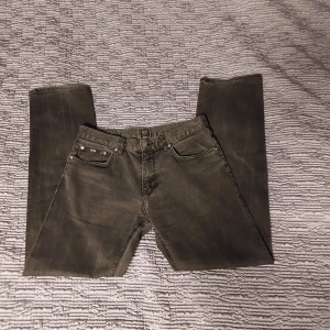 Svarta stretchjeans Hugo BOSS - Snygga svarta stretchjeans från BOSS med regular fit. Klassisk femficksmodell med silverfärgade nitar och diskret BOSS-logga på fickan. Jeansen har rak passform och är tillverkade i ett mjukt och följsamt jeanstyg. Storlek 33/34