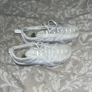 Nike Air VaporMax - Nike Air Max Plus sneakers i helvitt med reflekterande detaljer och klassisk vågig design. Skorna har snörning, mesh- och syntetmaterial samt synlig Air Max-dämpning i sulan. Perfekta för dig som gillar sportig och clean stil. Den är lite smutsig på vänster skon men man märker inte de som ni ser på bilderna, kan diskutera om priset! 