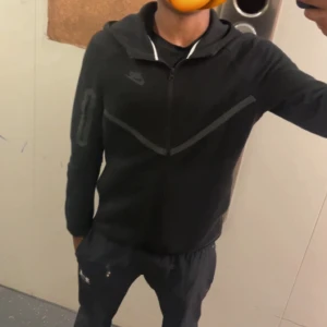 Svart Nike tech. - Inga större deeffekter, alltså som ny. Köpt på JD förra månaden, säljer för att den är liten. Inget kvitto eller äkthetsbevis. Passar mig som är 181 helt ok.